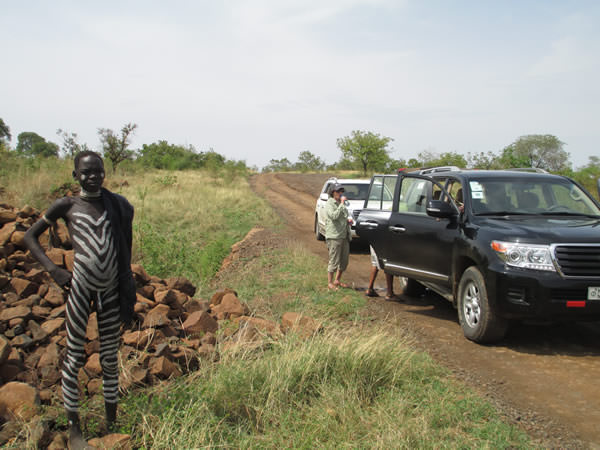 Tourists with local tribesman and vehicles in the Omo Valley